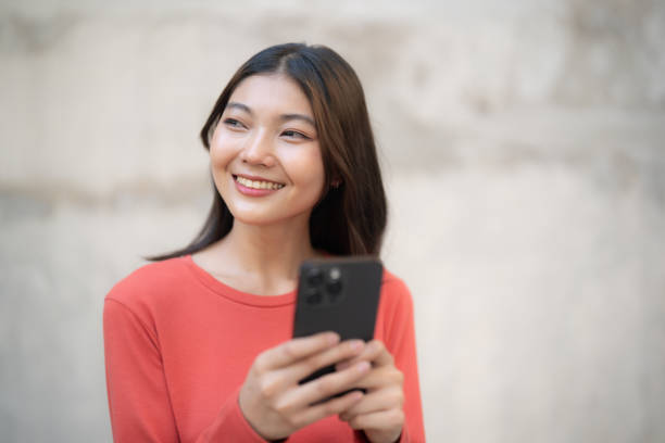 istock Content Woman Texting on Phone Against Wall. 2148421339