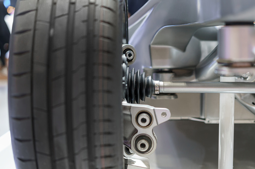 Explore the forefront of automotive engineering with a detailed view of the suspension structure and new tire on the front axle of an electric car. This cutting-edge design embodies the future of eco-friendly mobility