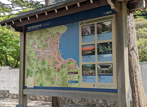 Kamakura, Japan - May 25, 2023: A tourist map displays photographs of popular cultural attractions in Kamakura City near Sagami Bay. Spring afternoon in Kanagawa Prefecture.