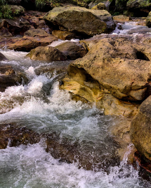 istock A natural scene of a rushing stream flowing over large, smooth rocks. 2148422716