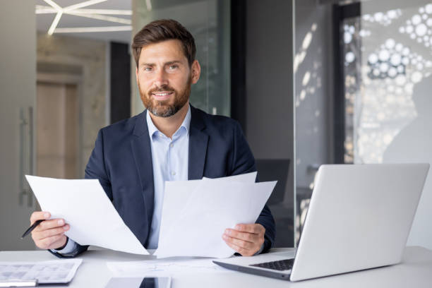 istock Smiling accountant with paperwork at modern office 2148423350