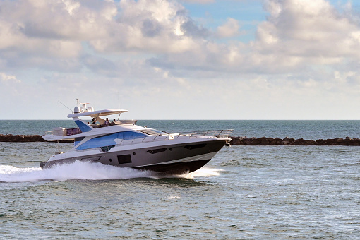 Miami, Florida, USA - 1 December 2023: Luxury motorboat at speed at the entrance to the port of Miami.