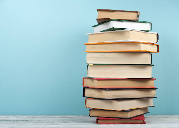 istock Open stacking book, hardback colorful books on wooden table and blue background. Back to school. Copy space for text. Education business concept. 2148425038