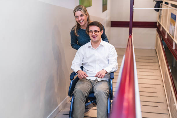 istock Shared Joy: Wheelchair Ride with a Laughing Man with Down Syndrome 2148428240