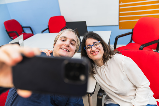 Two adults with mental disabilities enjoying a selfie at work.