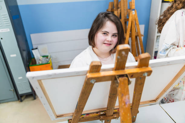 istock Young Woman with Down Syndrome Painting with Concentration in Class 2148429190