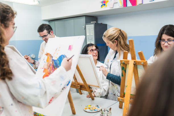 istock Art Instructor Offering Guidance to Student with Disability in Class 2148429569