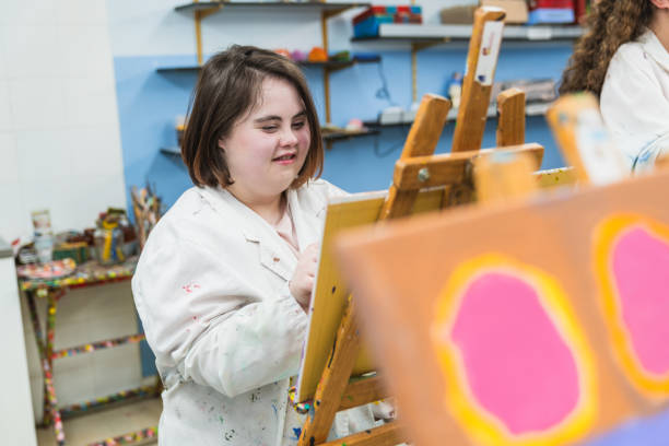 istock Focused Female Painter with Down Syndrome Creating Artwork 2148429638