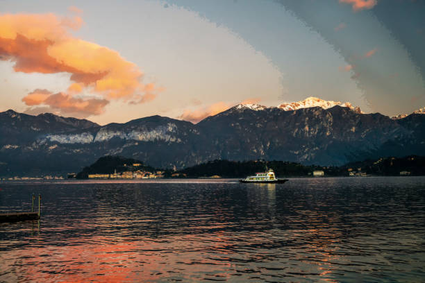 View of Lake Como, Italy at dusk. The shoreline and villages are illuminated by lights.