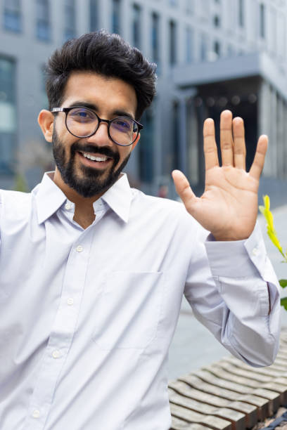 istock Cheerful businessman waving hello outdoors, friendly corporate professional greeting 2148430459