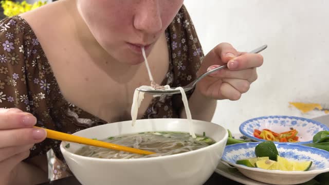 Close-up portrait of young women enjoy eating noodles in a cup at home. Junk food concept.