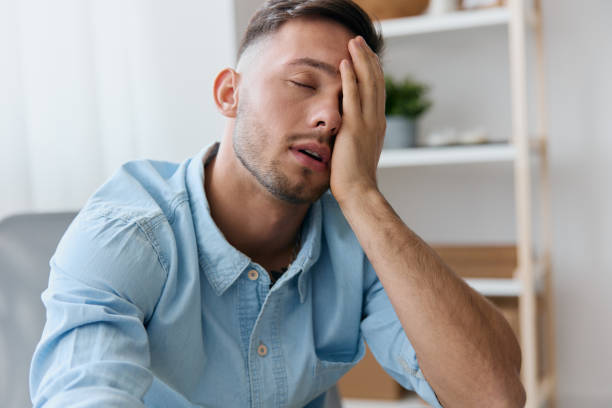 istock Tired frustrated young man reclines on hand closing eyes think about difficult life decision bad news health problem. Sleepy guy have depression need professional psychology help. Copy space for ad 2148432155