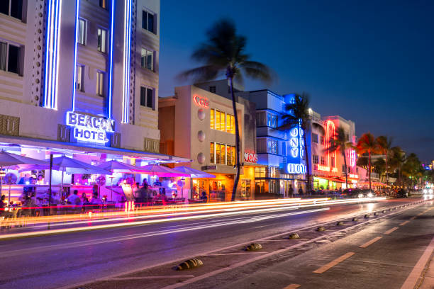 Miami, Florida - April 5, 2023:  People walk along Ocean Drive by the outdoor restaurants, bars, boutiques and luxury hotels in the Art Deco district in South Beach Miami at night