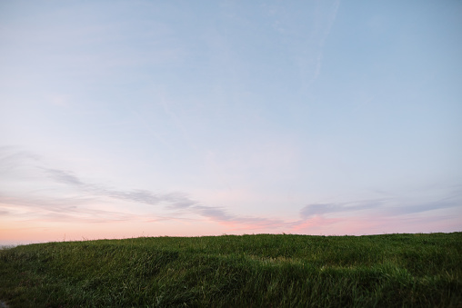 Sunset sky with pink tones over an agricultural field
