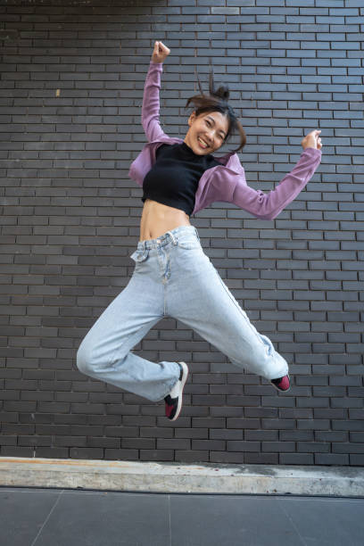 istock Energetic Young Woman Jumping in Joy. 2148436982
