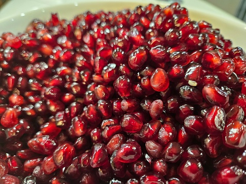 a close up view of a bowl of pomegranate arils served with salt and thyme powder