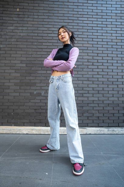 istock Stylish Young Woman Posing Against Brick Wall. 2148438446