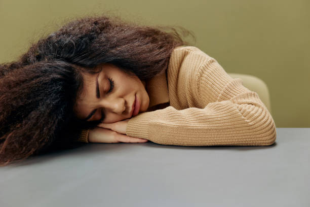 istock Sleeping tired dreaming tanned curly Latin student female with notebook sit at table isolated over olive green background. Copy space Mockup Banner. Studying overthinking offer 2148438616
