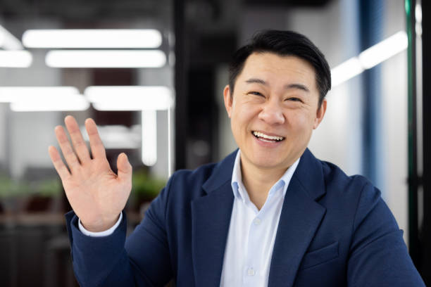 istock Friendly businessman greeting with a wave in the office 2148438722