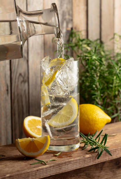 istock Water is poured from a decanter into a glass with ice and lemon slices. 2148438967