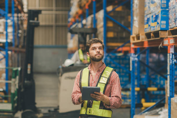 istock Warehouse worker working in warehouse storage. Foreman or worker work at factory site check up products in site. Inventory worker working in  factory Storehouse 2148439124