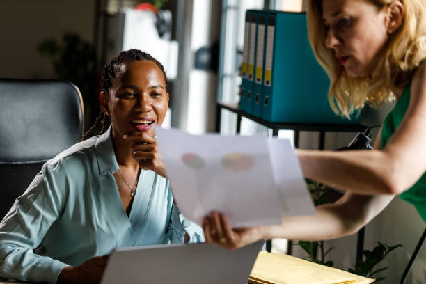 istock Businesswomen analyzing project document and coming up with solutions 2148439815