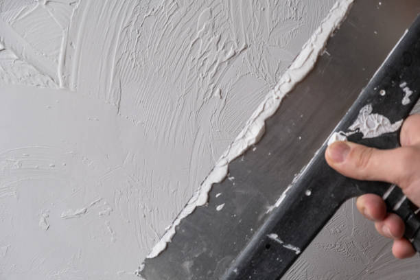 istock Applying decorative putty. White abstract texture of surface covered with putty 2148441228