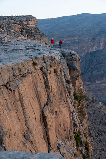 Two people at sunset standing at the edge of Oman - Grand Canyon/Wadi Nakha