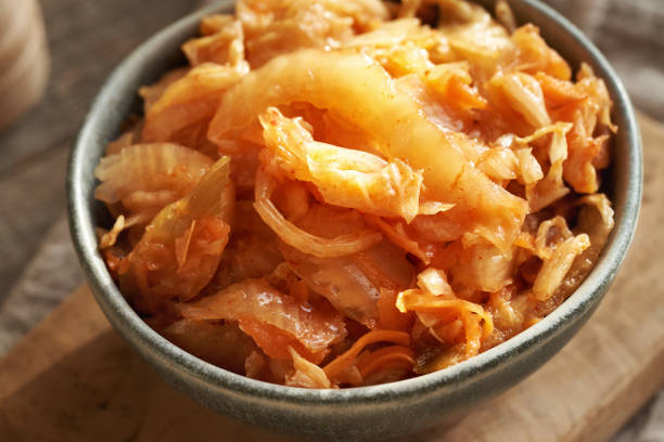 Closeup of fermented kim chi in a bowl on a wooden table