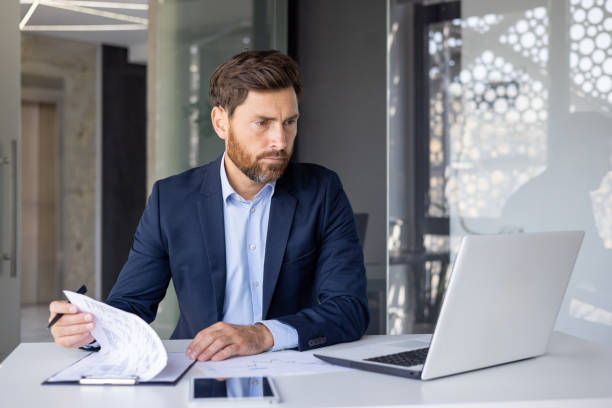 istock Serious accountant deep in thought over financial paperwork 2148441742