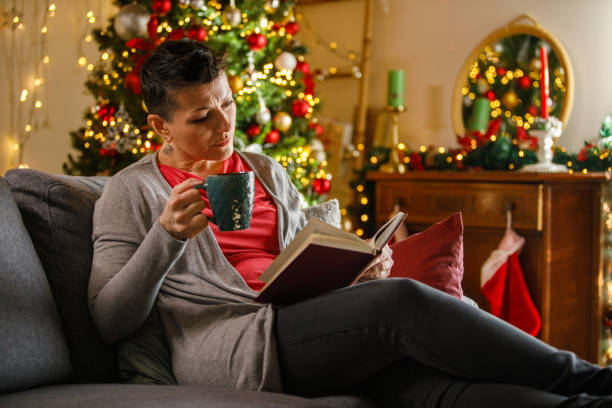 istock Woman reading a book, spending Christmas eve at home 2148442006