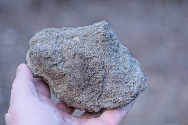 istock a man hand holds a large gray white piece of stone 2148442387