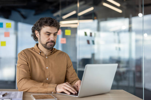 istock Professional man working on laptop in modern office space 2148442525