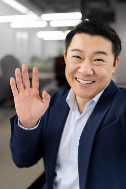 istock Friendly Asian businessman waving at the camera 2148442811