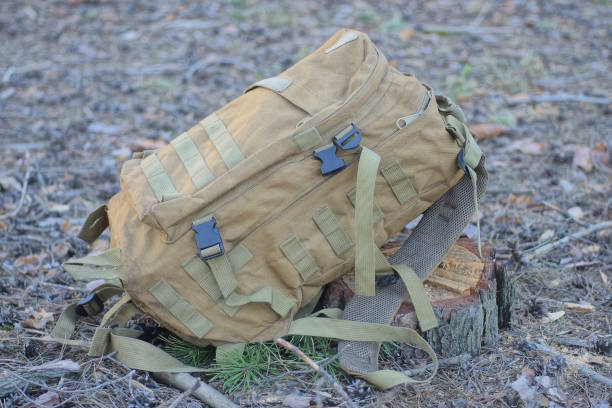 istock one full brown army backpack lies on the stump and ground 2148442868