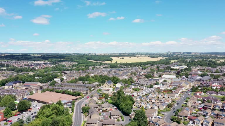 Aerial drone footage of the residential streets and roads in the town of Otley in Leeds West Yorkshire showing the British housing estates and suburban areas on a sunny day in the summer time