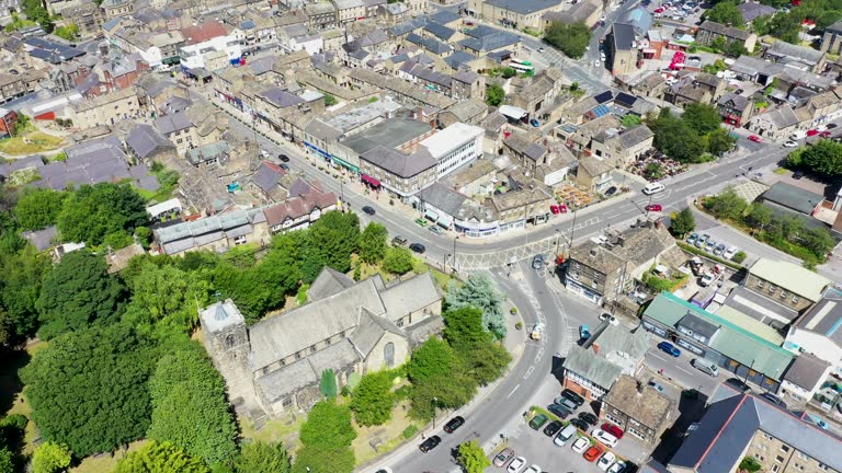 Aerial drone footage of the residential streets and roads in the town of Otley in Leeds West Yorkshire showing the British housing estates and suburban areas on a sunny day in the summer time