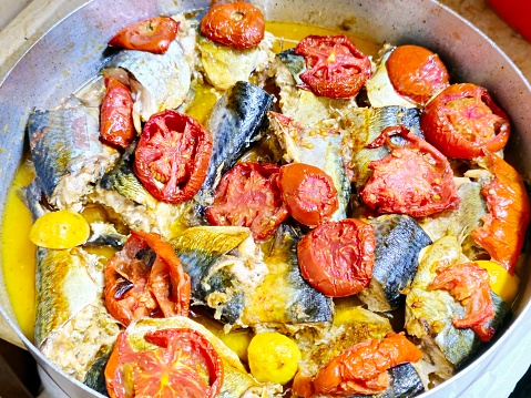 Mackerel fish, baked and cooked with tomatoes, different species of pelagic fish, mostly from the family Scombridae, Mackerel species typically have deeply forked tails and vertical tiger-like stripes, selective focus
