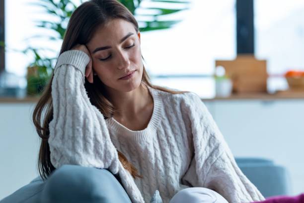 istock Depressed young woman thinking about her problems while sitting on the sofa at home. 2148443927