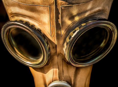 Gas mask appears to be made of leather and covered most of the head. Focus on the eye goggles.