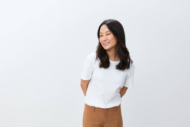 istock Attractive cutie Korean Asian young female in white basic t-shirt smiling at camera posing isolated on over white studio background. The best offer for ad. People Lifestyle concept. Copy space 2148444329
