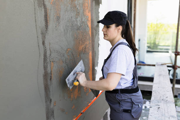 istock Female worker applying plaster on exterior wall 2148446004