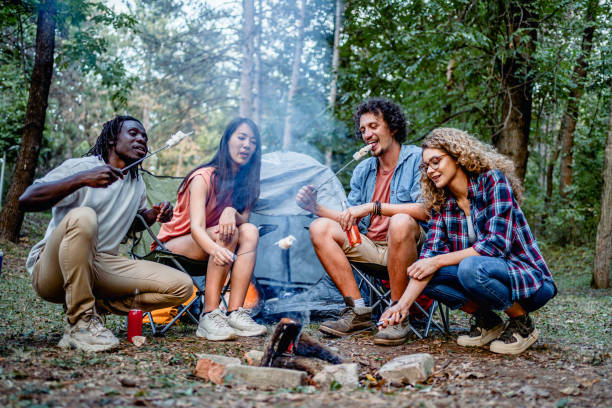 Friends roasting marshmallows together at camping