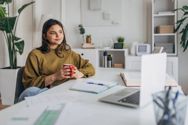 istock Young woman enjoying coffee during work at home 2148446434