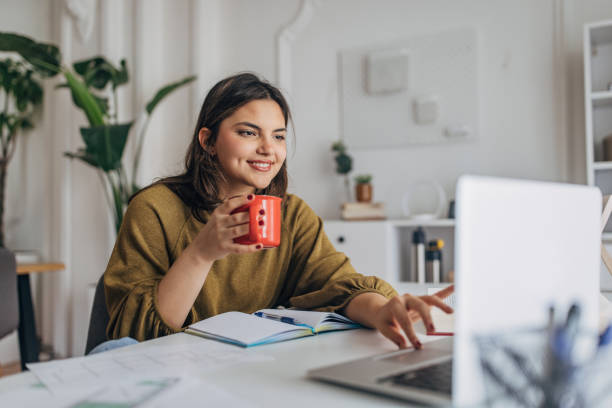 istock Young woman enjoying coffee during laptop work 2148446533
