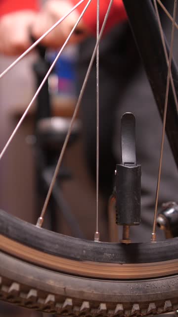 vertical video close-up of inflating a bicycle tire, wheel with a hand air pump