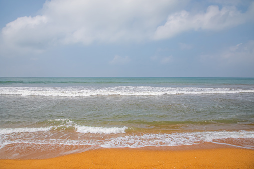beautiful ocher beach in sri lanka. deserted shore of Indian ocean with bright orange sand. Traditional ordinary local