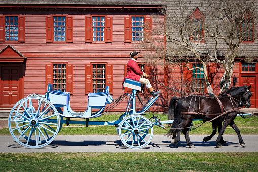 A horse-drawn carriage travels the streets of Colonial Williamsburg, Virginia.