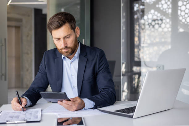 istock Serious accountant reviewing financial documents in office 2148447764