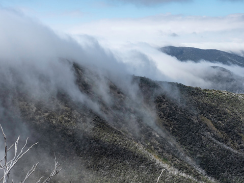 Clouds flowing down mountain side at Mount Hotham Victoria